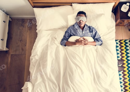 Preview: Black man sleeping on bed with eye mask