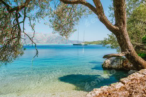 Preview: Summer vacation in Greece. Sea bay view framed with old olive tree and luxury yacht in lagoon in a