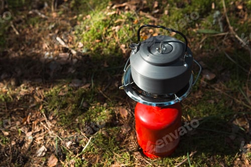 Preview: Cooking, heating a tourist kettle on a portable gas burner with a red gas cylinder