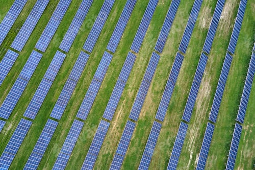 Preview: Aerial view of big sustainable electric power plant with many rows of solar photovoltaic panels for
