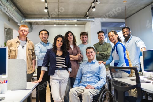 Preview: Confident business team posing in modern coworking space with disabled colleague