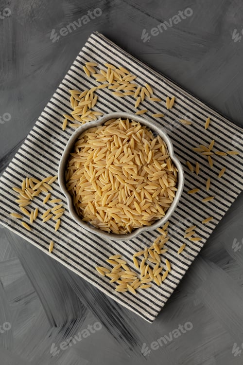 Preview: Raw Organic Orzo Pasta in a Bowl, top view. From above, overhead, flat lay.