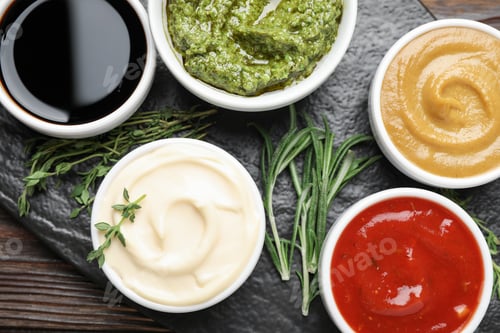 Preview: Different sauces and herbs on wooden table, flat lay