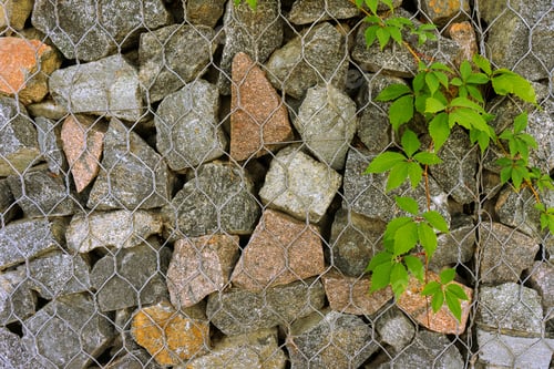 Preview: Gabion, texture, background. Wall made of natural rocks and metal fences.