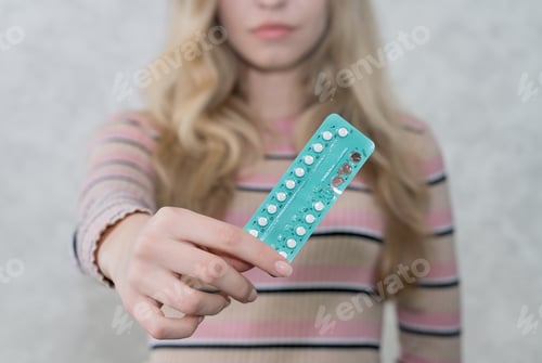 Preview: blister of oral contraceptives in female hands, soft focus, women's health