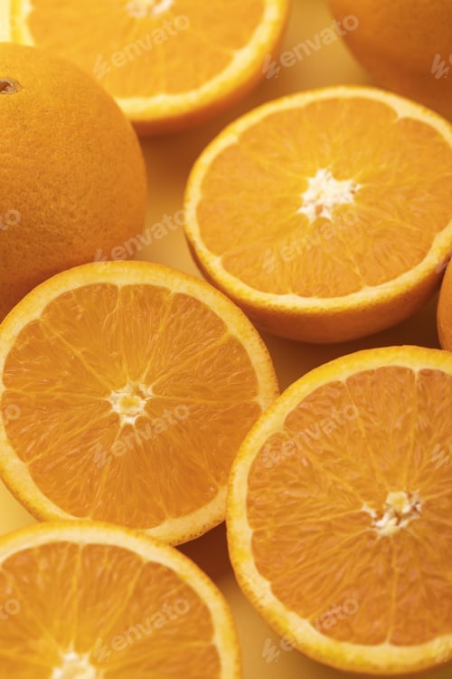 Preview: Vertical shot of slices of fresh orange on a yellow surface
