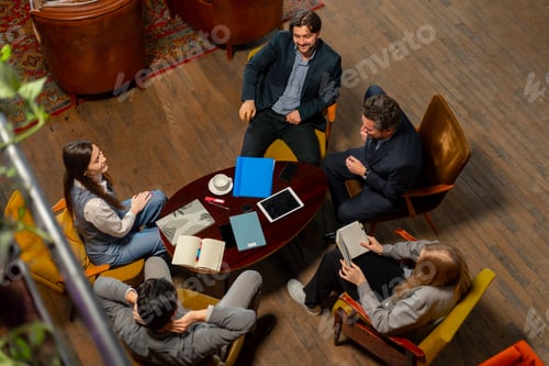 Preview: top shot in large beautiful hall office employees sitting on yellow chairs discuss a deal