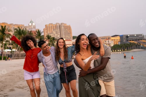 Preview: Relaxed golden hour lifestyle of young friends on a tropical beach, enjoying the warm sunset