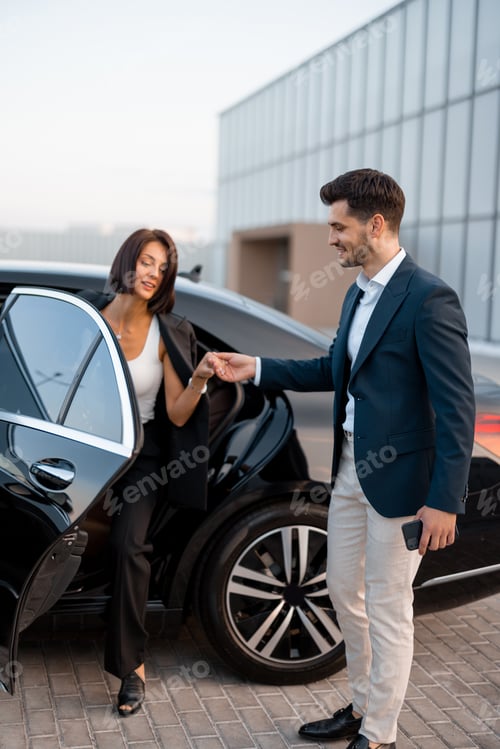 Preview: Businessman helps a woman to get out of a car