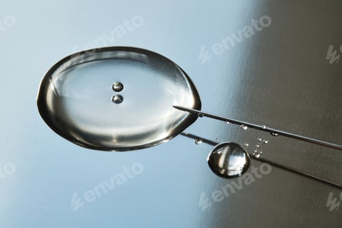 Preview: A drop of medicine flowing from a syringe with a needle.
