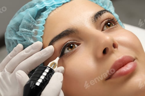 Preview: Young woman undergoing procedure of permanent eyeliner makeup, closeup