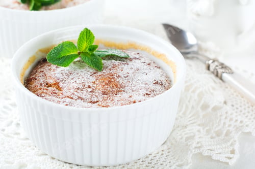 Preview: Cheese Casserole with pumpkin and cinnamon for breakfast in a white ceramic form on a light backgrou