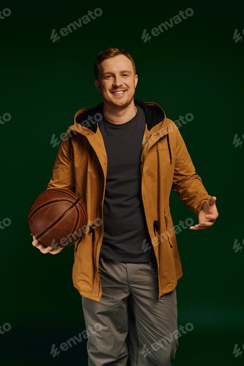 Preview: Stylish man poses with a basketball in a bright studio scene
