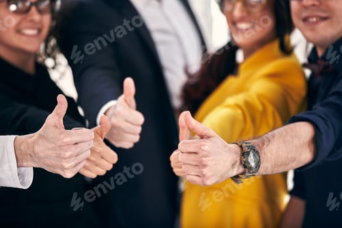 Preview: Group of cheerful business people in casual wear standing close to each other and showing their