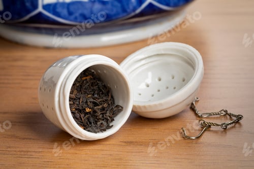 Preview: White ceramic open tea strainer with dried Chinese Kee Mun tea leaves close up