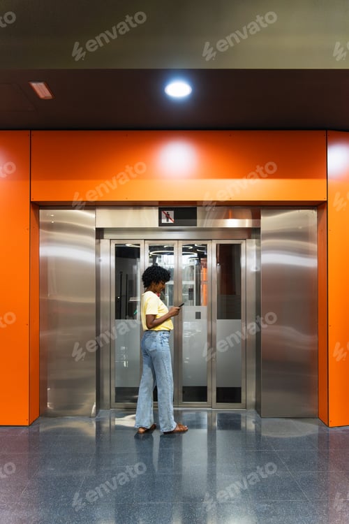 Preview: Young woman using mobile phone at subway station