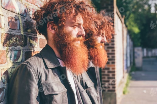Preview: Young male hipster twins with red hair and beards leaning against brick wall