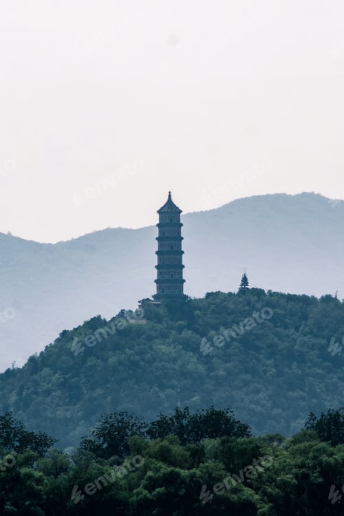 Preview: Majestic ivory-hued tower stands atop a rolling green hill dotted with lush trees.