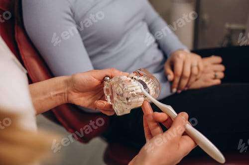 Preview: Dentist inserting retainers. Mouthguard with wooden toothbrush in doctors hands in blue gloves, teen