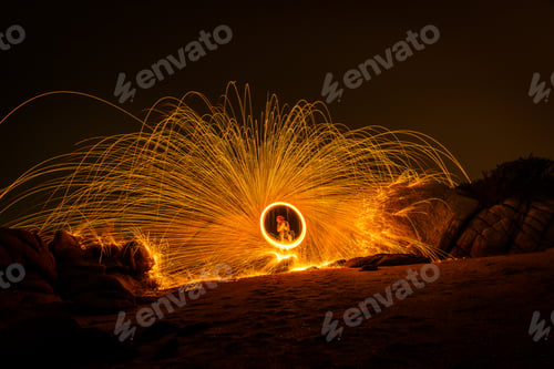 Preview: Fire dancing show swing lighting effects circle on bridge dark sky on night time.