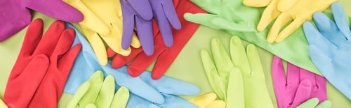 Preview: panoramic shot of scattered multicolored rubber gloves on green background