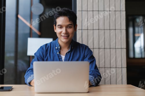 Preview: Young asian freelancer working on laptop in modern office