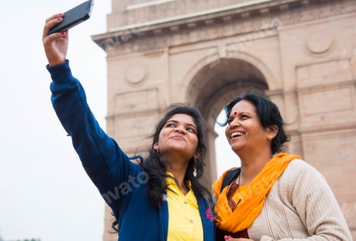 Preview: Tourist taking selfie with smart phone in front of India Gate, Delhi, India.