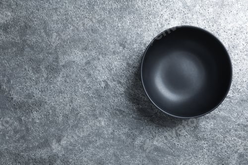 Preview: Empty clean ceramic bowl on grey table, top view. Space for text