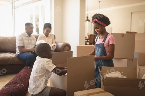 Preview: African American children unpacking their belongings and parents sitting on sofa at home