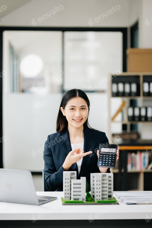 Preview: Real estate agent worker working with laptop and tablet at table in office and small house