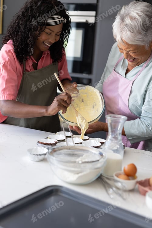 Preview: Grandmother and daughter baking cupcakes together, sharing laughter in kitchen