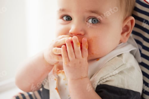 Preview: Playful Baby Eating Messily With Tomato in Hands