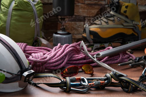 Preview: wooden table with climbing equipment, rope, carabiners, ice axe,