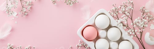 Preview: Easter eggs in white ceramic holder and flowers on pink background