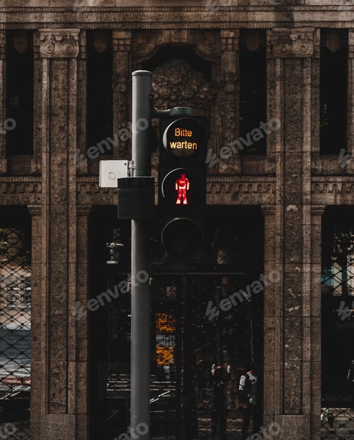 Preview: Vertical shot of a traffic light for pedestrians near the old building