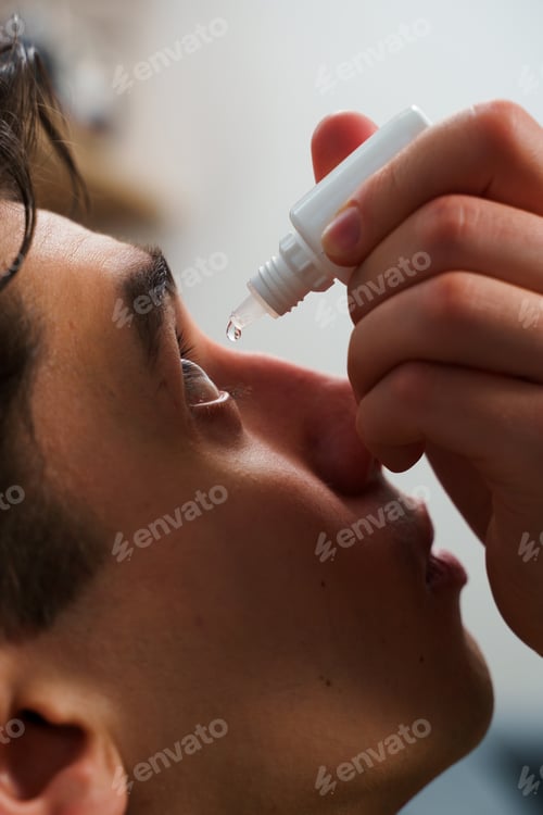 Preview: Young man using eye drops for irritation relief