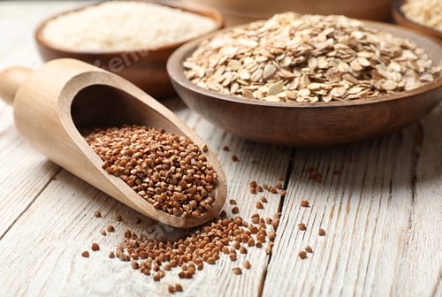 Preview: Scoop with buckwheat on wooden table, closeup. Grains and cereals