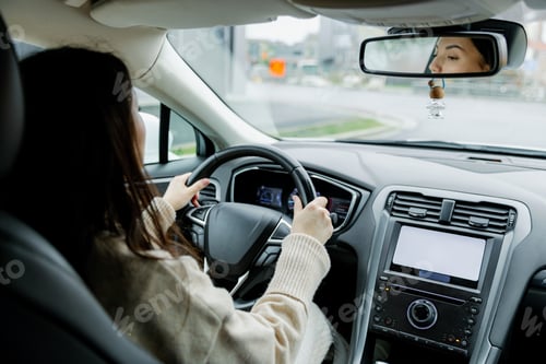 Preview: Portrait of a young woman driving a car.