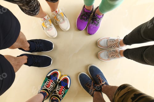 Preview: Closeup view of people in stylish training shoes standing on floor indoors, top view