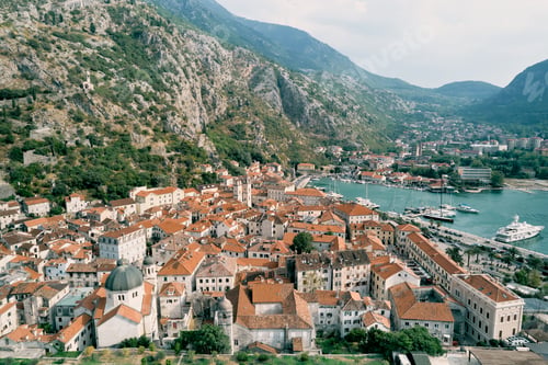 Preview: Ancient town of Kotor at the foot of the mountains with a pier on the seashore. Montenegro. Drone