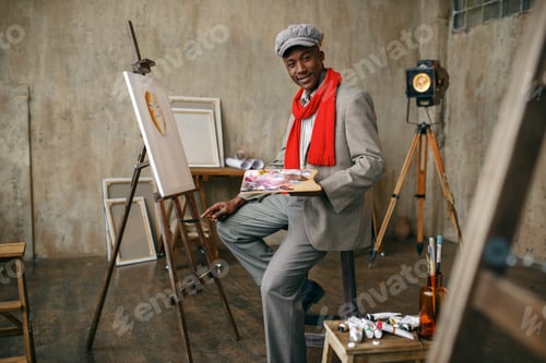 Preview: Happy painter draws female model in art studio