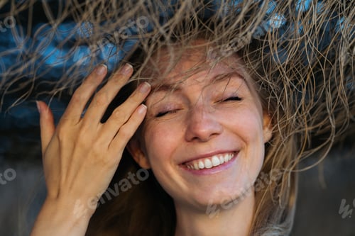 Preview: Close-up portrait of caucasian young woman smiling with closed eyes.