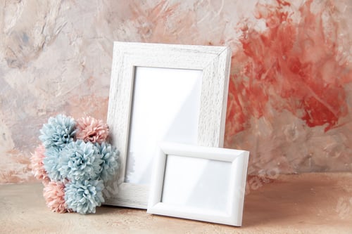 Preview: Front view of white empty wooden photo frames and flower on pastel colors background