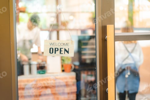 Preview: Hand of coffee shop staff woman wearing apron turning open sign board on glass door