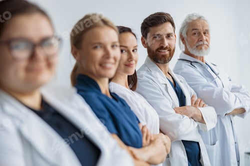 Preview: Group of doctors standing in a line keeping arms crossed and looking camera at the modern clinic