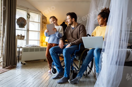 Preview: Happy father in wheelchair with interracial daughters using laptop together, education, fun concept