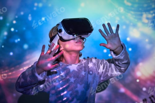 Preview: Delighted kid interacting with VR glasses in neon lights