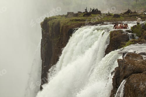 Preview: Tourists enjoying the magnificent view atop a powerful waterfall