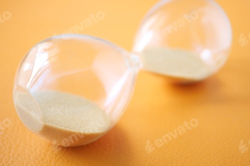 Preview: hourglass on table, sand flowing through the bulb of sandglass