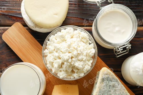 Preview: Fresh dairy products and cutting board on wooden background, top view